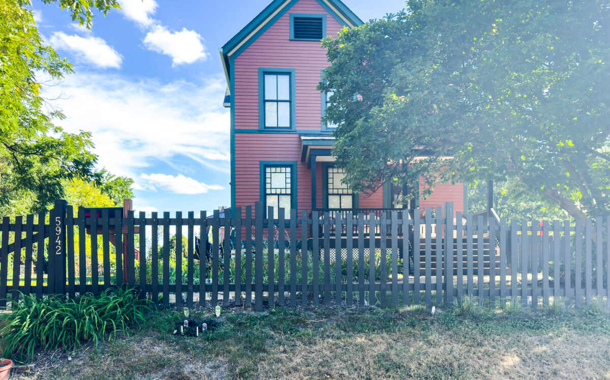 Pink Victorian home with teal window trim