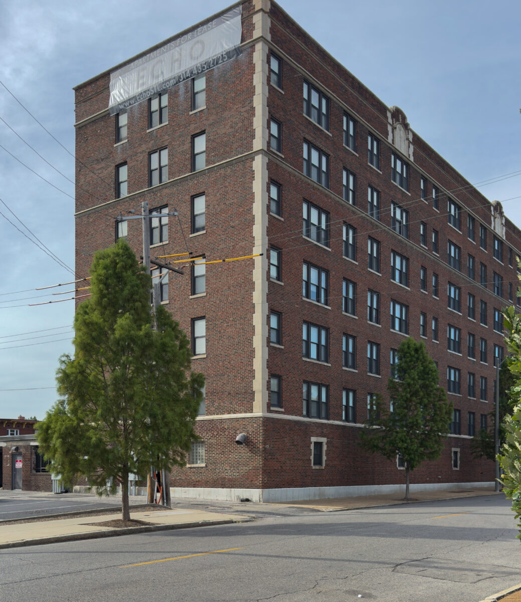 Brick apartment building on street corner.