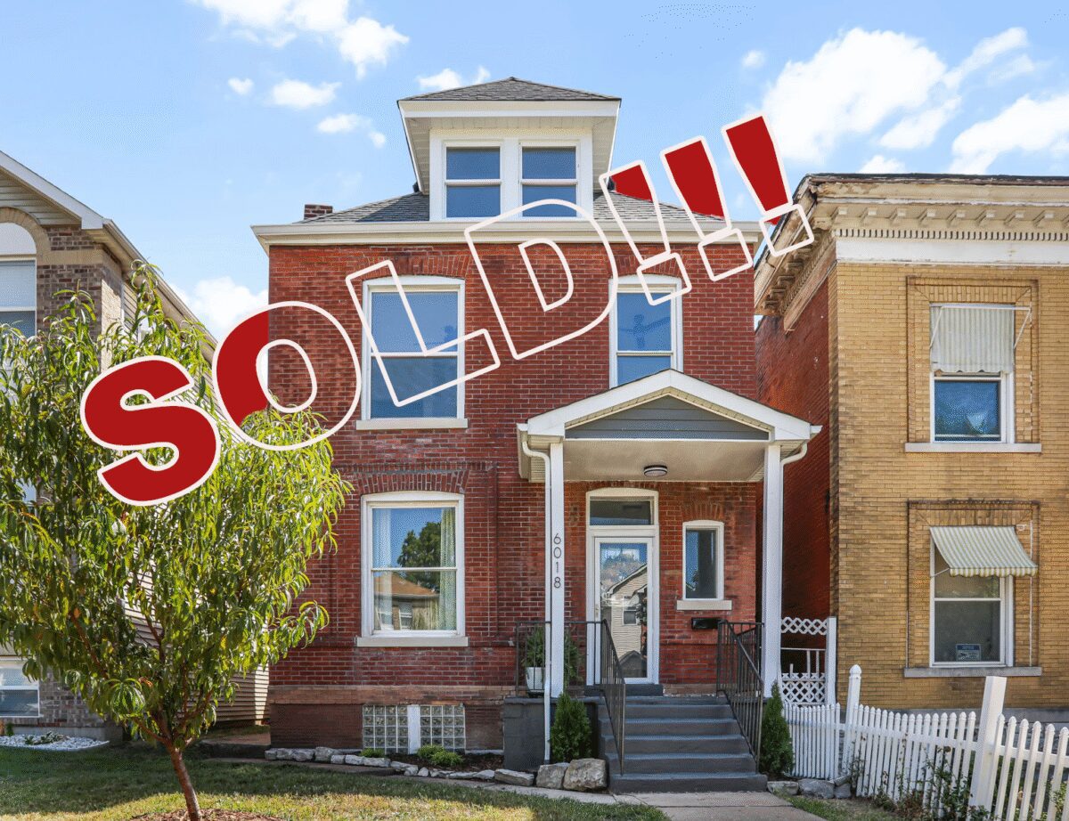 Red brick house with "Sold" sign.